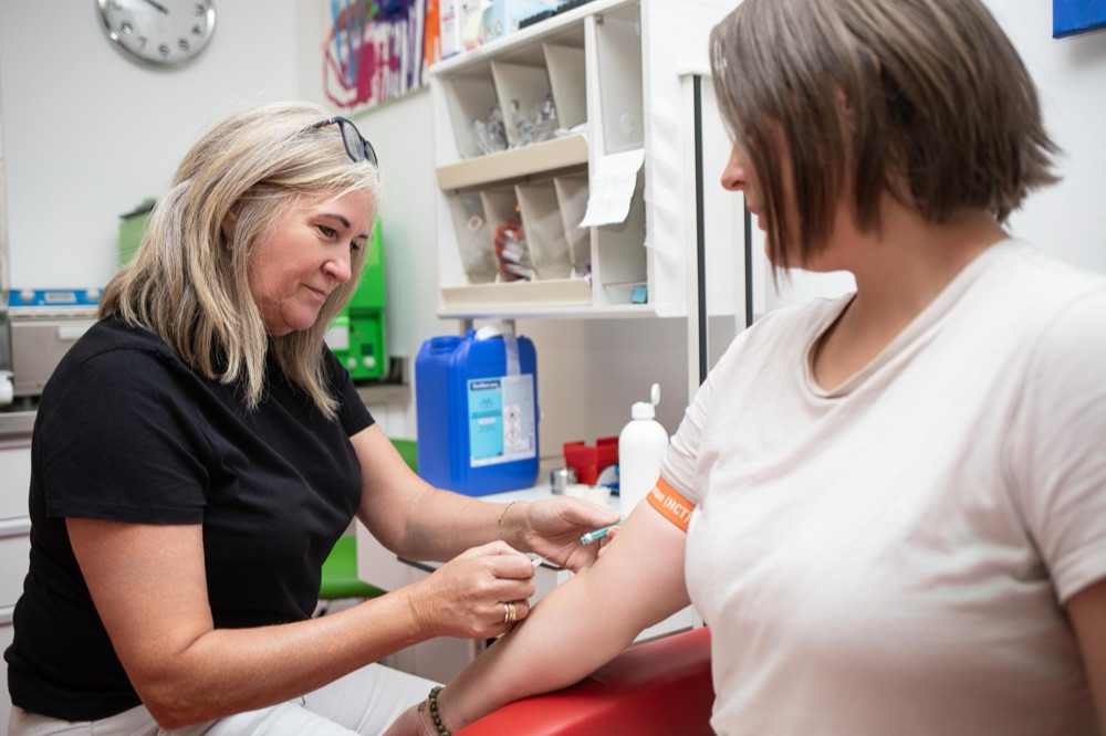 Ordinationsassistentin nimmt einer Patientin Blut ab.